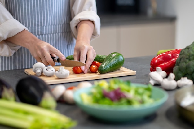 Mujer cocinando el almuerzo y cortando verduras