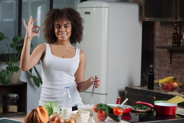 Mujer cocinando y haciendo gesto de ok