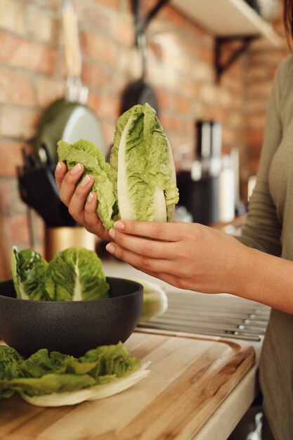 Mujer cocinando con lechuga