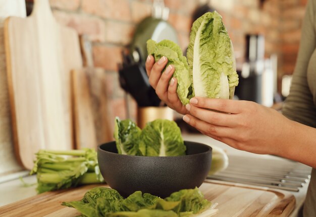 Mujer cocinando con lechuga