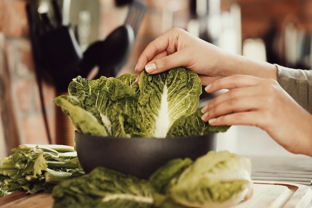 Mujer cocinando con lechuga