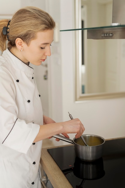 Mujer cocinando en olla de tiro medio