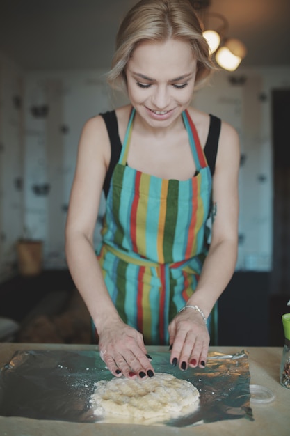 Mujer cocinando pizza en la cocina