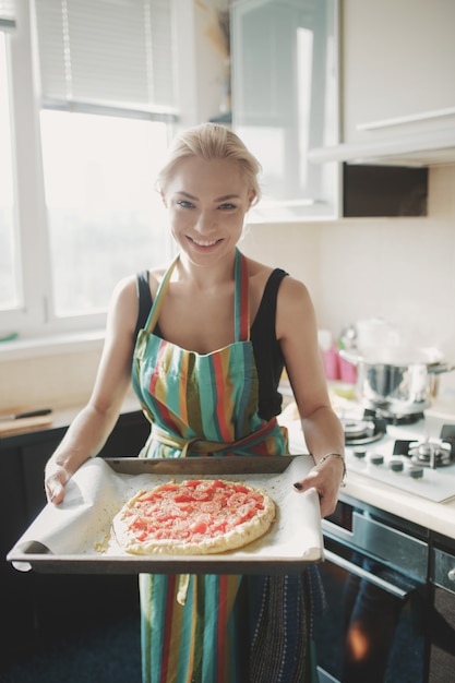 Mujer cocinando pizza en la cocina