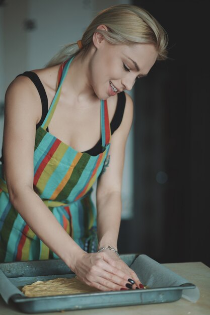 Mujer cocinando pizza en la cocina