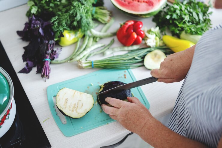 Foto gratuito mujer cocinando verduras en la cocina.