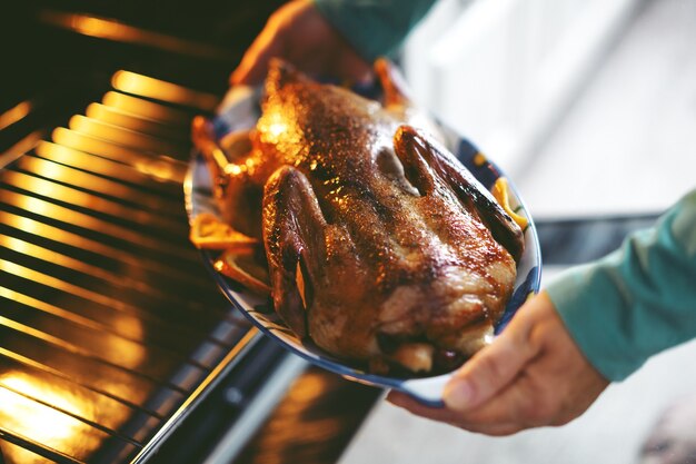 Mujer cocinar pato con verduras y ponerlo del horno.