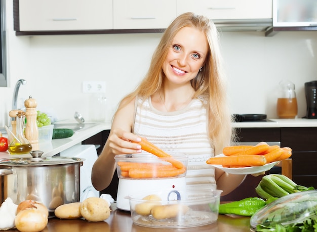 mujer cocinar verduras con vapor eléctrico