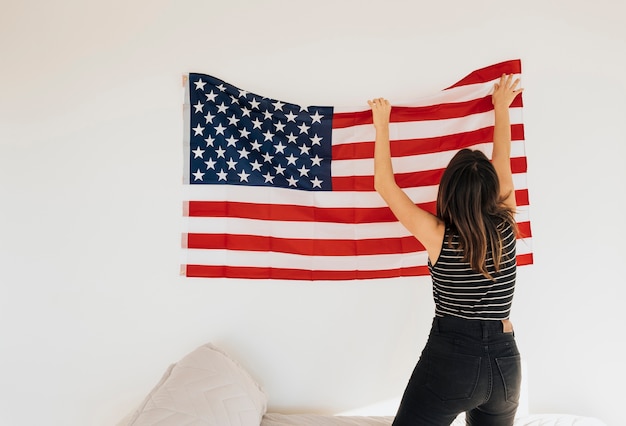 Mujer colgando bandera nacional en pared