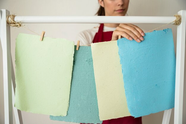 Mujer colgando coloridos papeles hechos a mano en cadena
