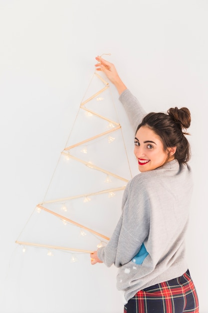 Mujer colgando de madera árbol de navidad