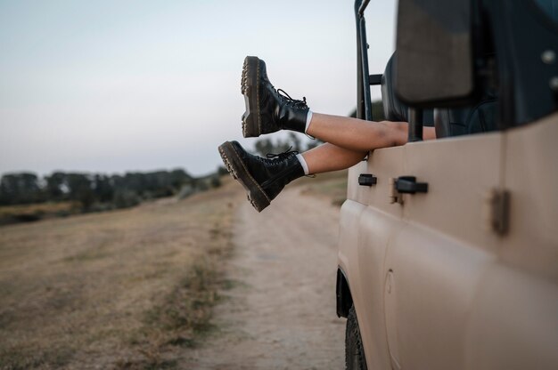 Mujer colgando sus pies sobre el coche mientras viaja