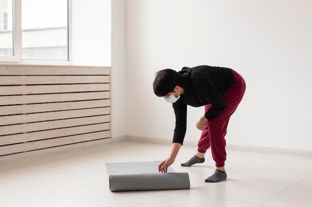 Mujer colocando una estera de yoga en el suelo