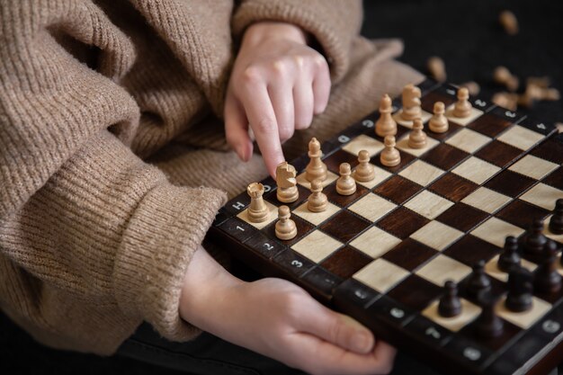 Mujer colocando piezas de ajedrez en un tablero de ajedrez