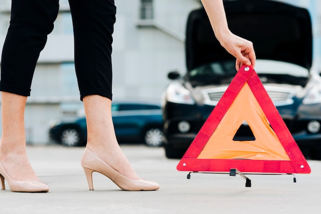 Mujer colocando señal de emergencia