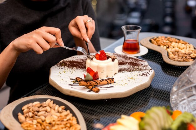 Mujer come pastel de malvavisco con fresa