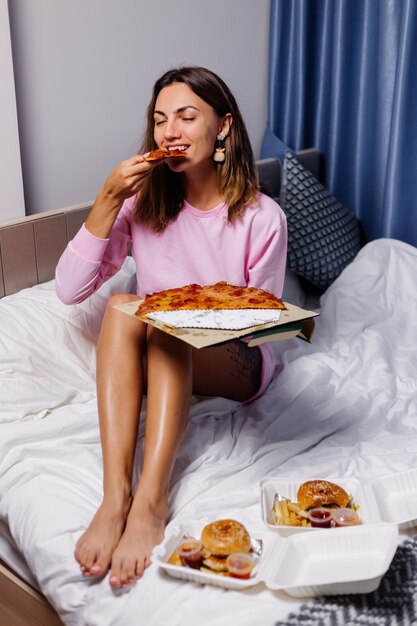 Mujer come pizza en casa