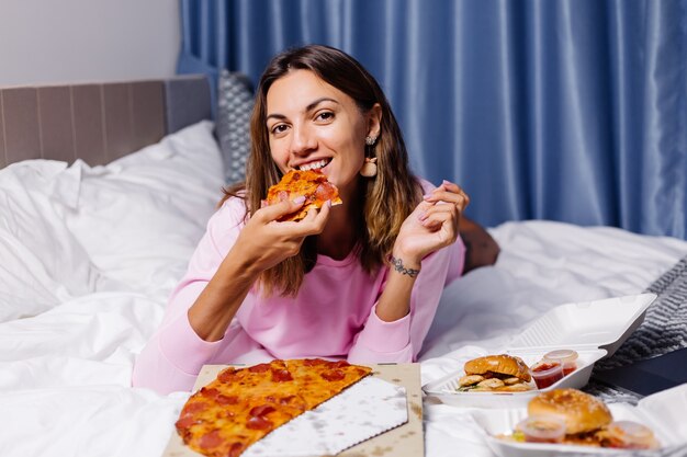 Mujer come pizza en casa