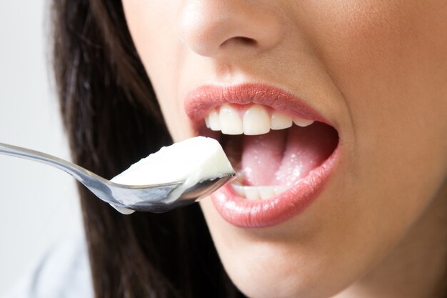Mujer comer yogur con cuchara