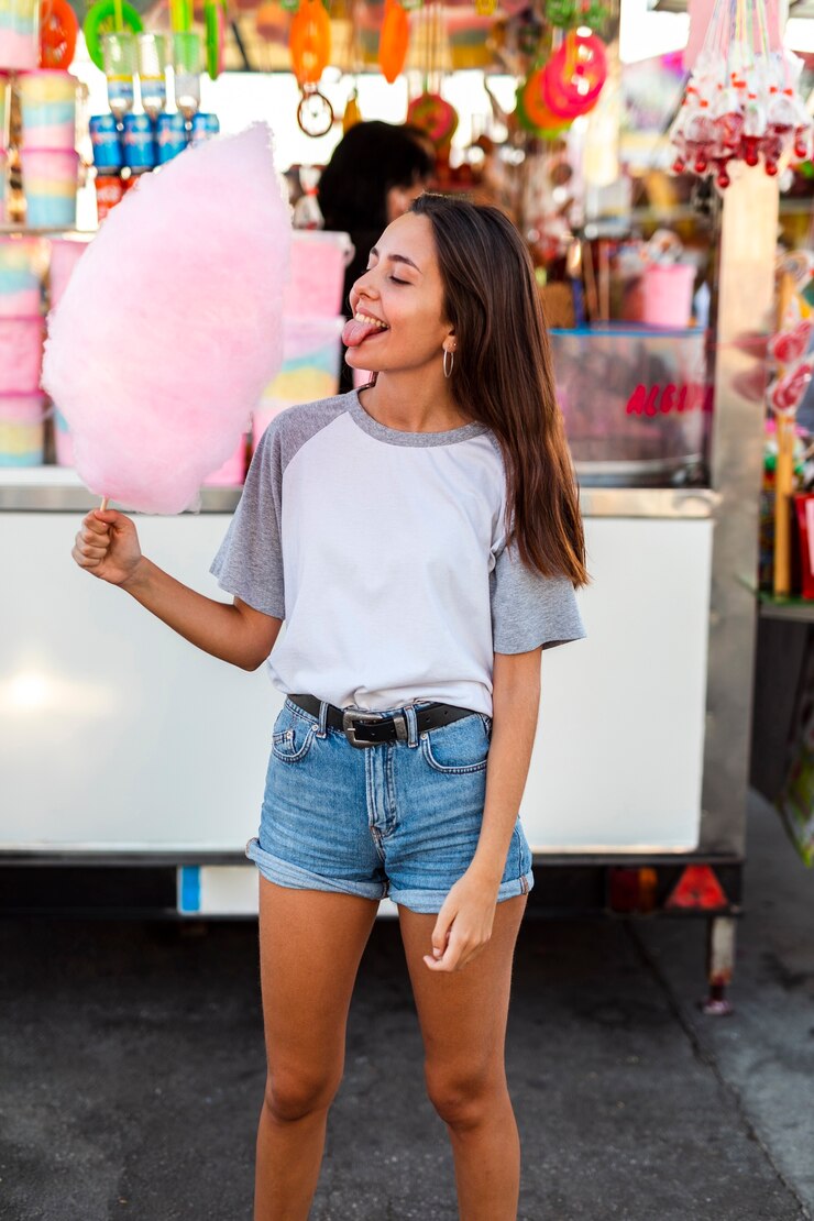 Foto gratuito mujer comiendo algodón de azúcar rosa
