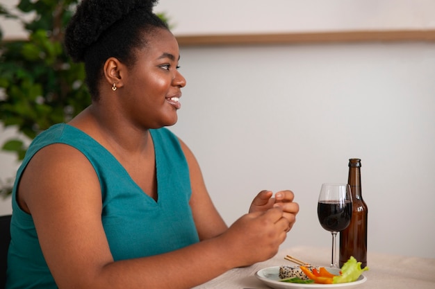 Foto gratuita mujer comiendo y bebiendo en una cena