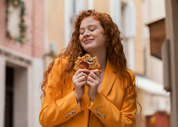 Mujer comiendo comida en la calle al aire libre