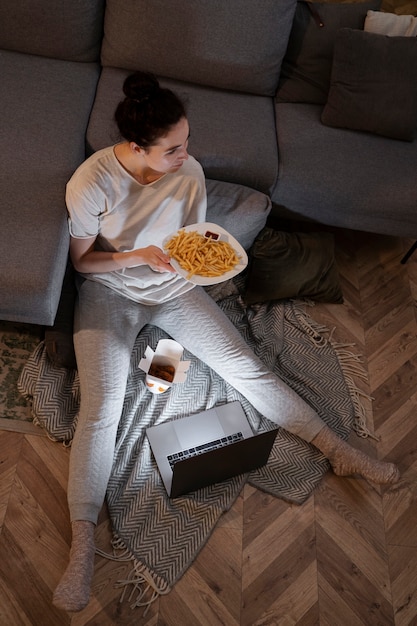 Foto gratuita mujer comiendo comida rápida mientras ve una película