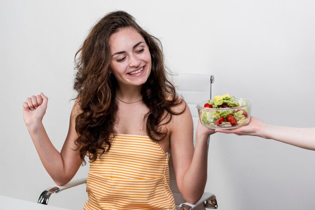 Mujer comiendo una ensalada de lechuga