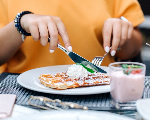 Mujer comiendo gofres con crema 1