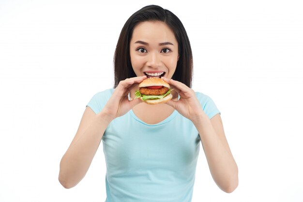 Mujer comiendo hamburguesa de pollo