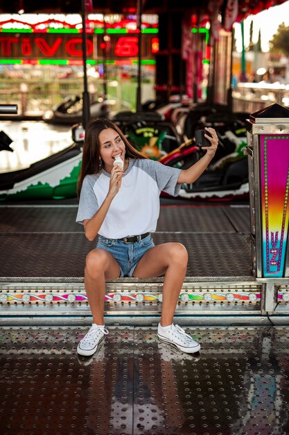 Mujer comiendo helado tomando selfie