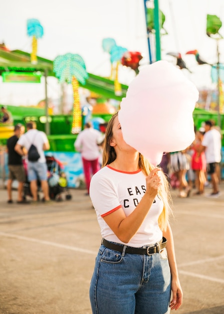 Foto gratuita mujer comiendo hilo rosa caramelo