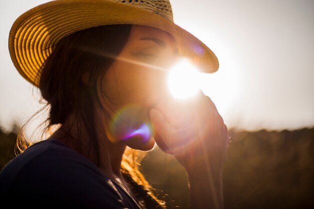 Mujer comiendo manzana roja en la luz del sol