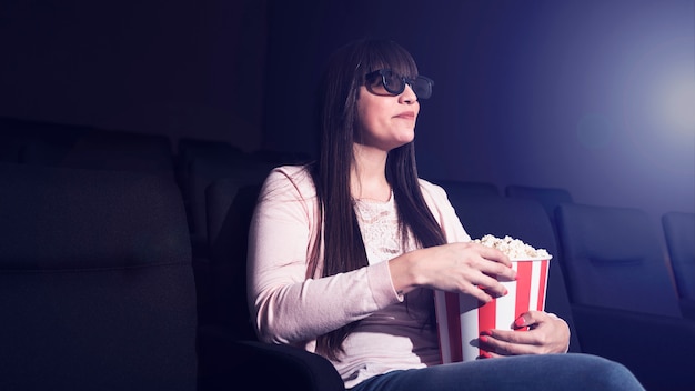 Foto gratuita mujer comiendo palomitas en cine