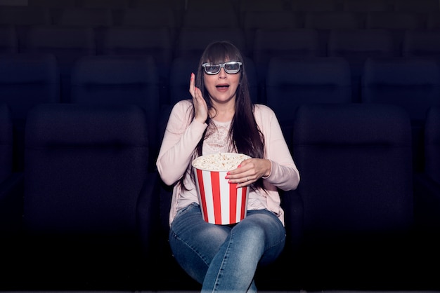 Mujer comiendo palomitas en cine