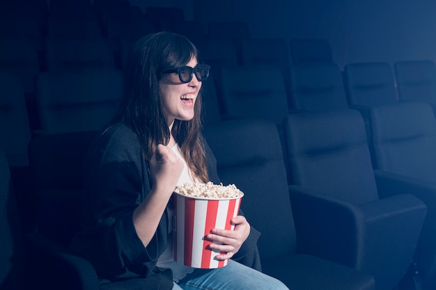 Mujer comiendo palomitas en cine