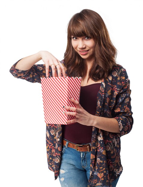 Mujer comiendo palomitas de un paquete de palomitas