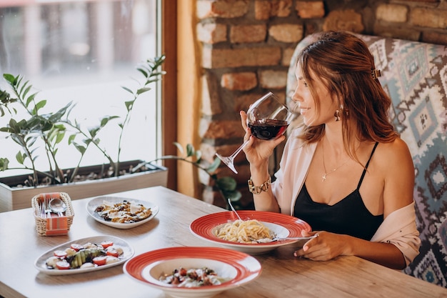 Mujer comiendo pasta en un restaurante italiano