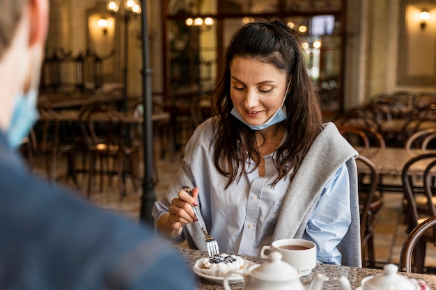 Mujer comiendo pastel en el restaurante