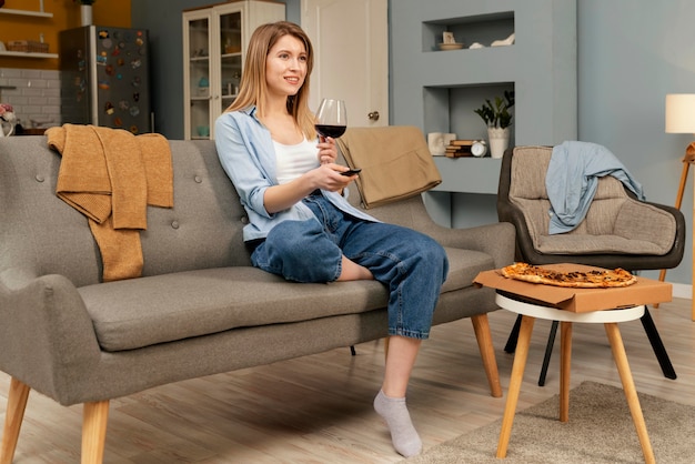 Mujer comiendo pizza mientras ve la televisión