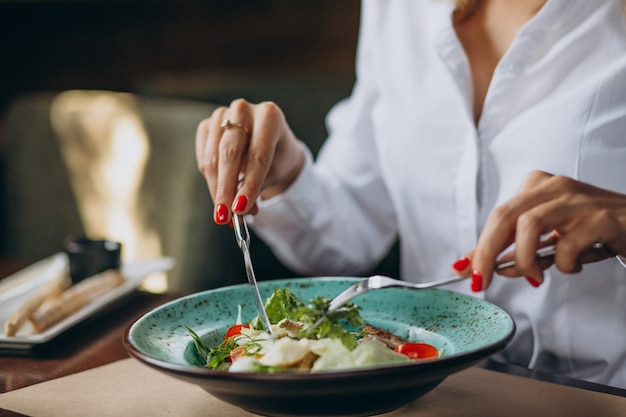 Mujer comiendo plato de ensalada