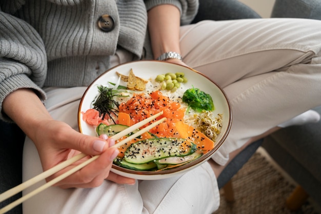 Mujer comiendo plato de mariscos con salmón