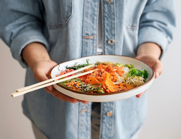 Foto gratuita mujer comiendo plato de mariscos con salmón