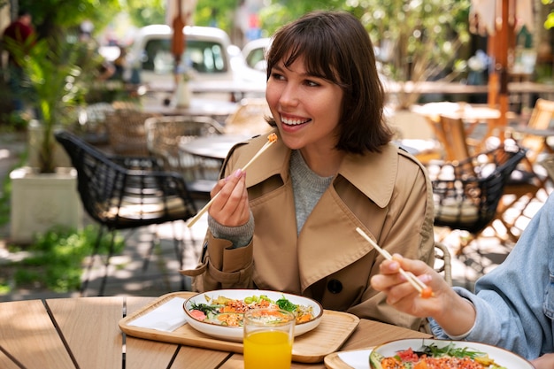 Foto gratuita mujer comiendo plato de mariscos con salmón