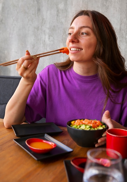 Foto gratuita mujer comiendo plato de salmón en el restaurante