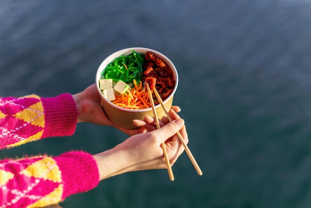 Una mujer comiendo un poke