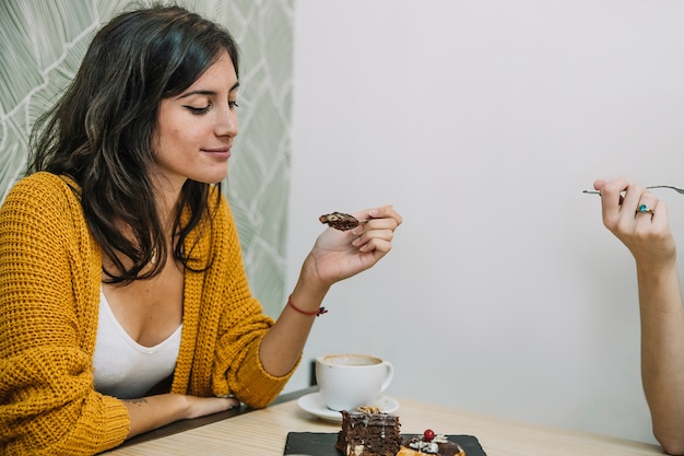 Mujer comiendo postre con amigo