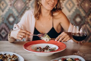 Foto gratis mujer comiendo ravioles en un restaurante italiano
