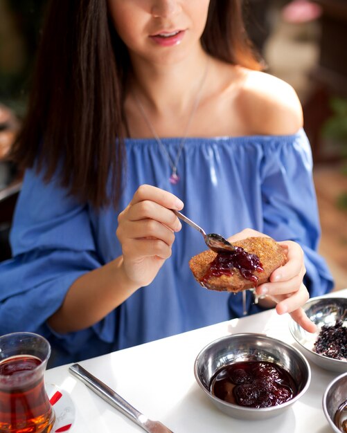 Mujer comiendo tostadas francesas con mermelada de fresa