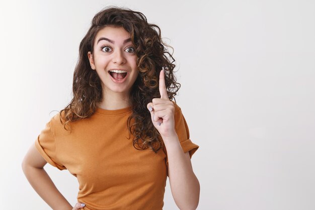 mujer compartir pensamientos levantar el dedo índice eureka gesto sonriente abrir la boca diciéndonos un plan increíble